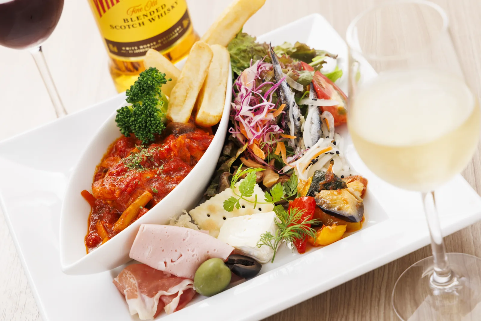 60分飲み放題プランのおつまみ。前菜盛り合わせ、サラダ、トマト煮、フライドポテトに赤白のワインとウイスキー